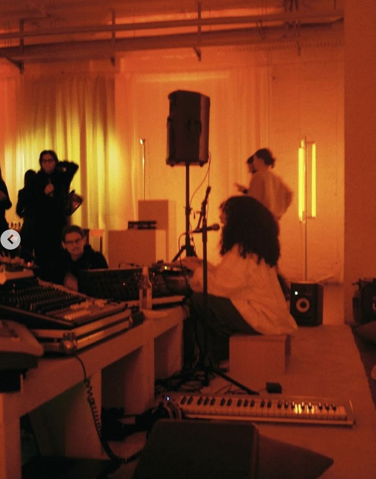 An intimate, warmly-lit live session — performer and witness in close quarters